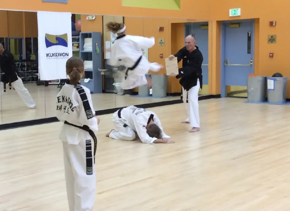 Student doing a jumping kick during a belt test